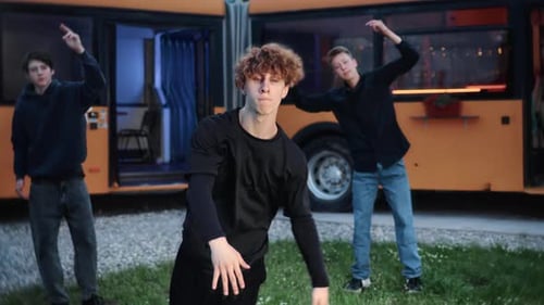 Young Adults Dancing Outdoors in Front of Bus