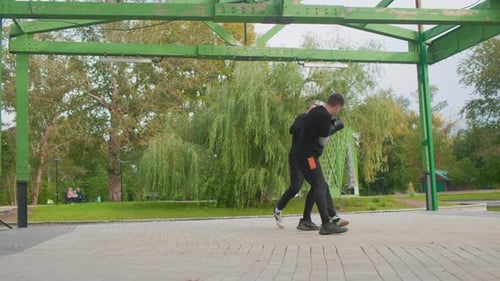 Men Sparring in Park Two Men Training with Quick Punches in Park Environment Two Individuals Engaged