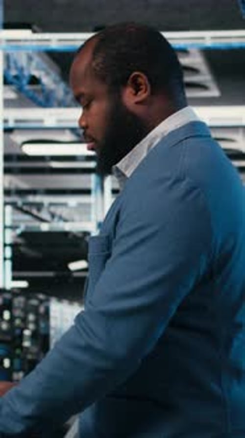 Vertical Video Using Laptop Workspace Desk and Technician in Server Hub