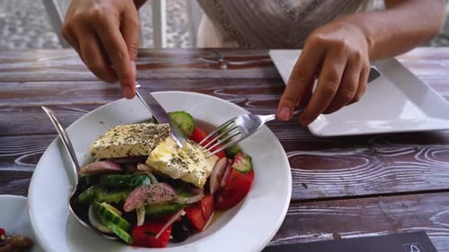 Quelqu'un mangeant une salade grecque