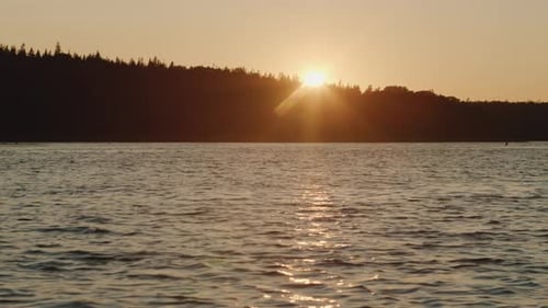 Beautiful Sunset on a Calm Ocean with a Forest on the Island