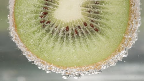 From Kiwi in soda bubbles rise up. Macro