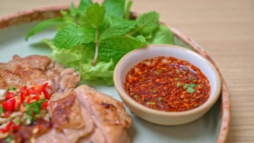 Delicious Grilled Chicken Garnished with Herbs and Chili Peppers