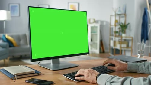 Over the Shoulder Shot of Professional Freelancer Working on Green Mockup Screen Personal Computer