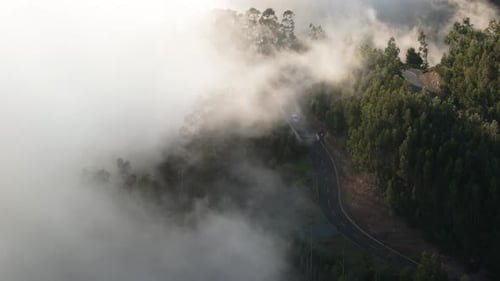 Cloud Covered Mountain Road And Vehicle Passing By