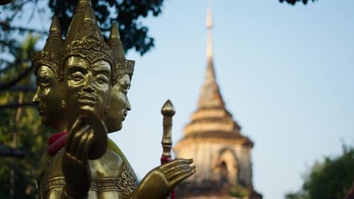 Closeup of a Copper Buddhist Statue in Front of the Large Stone Temple in Thailand