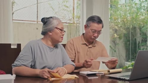 Senior Couple Reviews Finances Together at Home