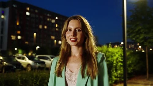 Beautiful Girl Posing for Camera on the Background of a City Block at Night Slow Motion Dynamic