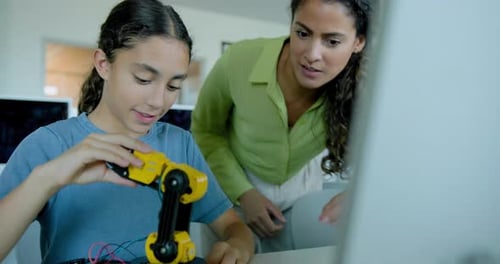 Girl Builds Robot with Help from Adult