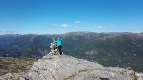 Man Reaches Mountain Peak On Sunny Day