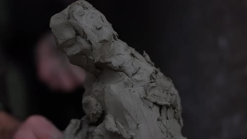 Sculptor Shaping Clay into Woman’s Figure with Artisan Hands in Traditional Pottery Studio