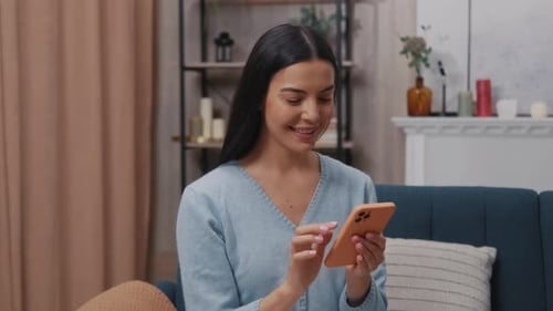 Woman Using Cell Phone While Sitting on Couch