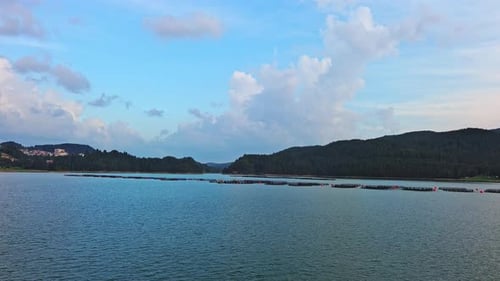 Fishing Cages for Breeding Fish in Lake in Mountain Valley of Rhodope Mountains Under Cloudy Sky
