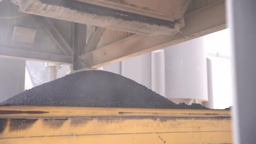 Asphalt, der für die Verlegung auf den Straßen vorbereitet ist, wird auf Lastwagen verladen