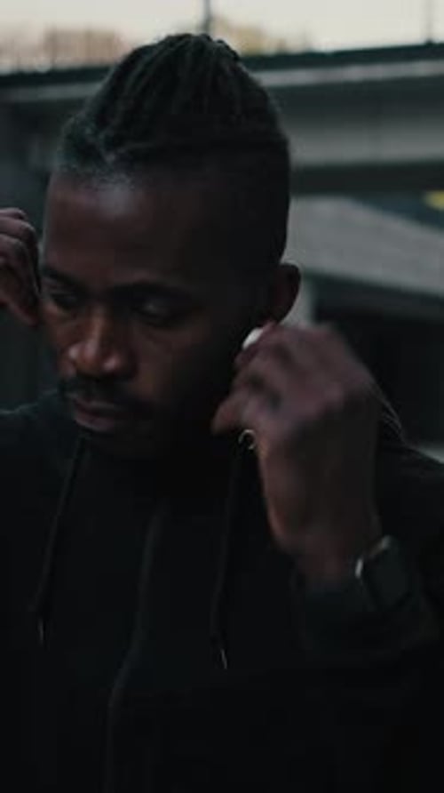 Music Lover Close Up Portrait of Sporty African American Man Putting on Wireless Earphones and Start