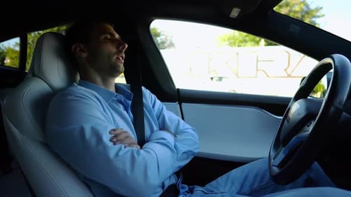 Male Businessperson Experience to Ride an Autonomous Self Driving Electric Car at Urban Road