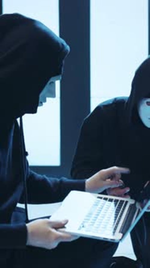 Mysterious Figures Dressed in Hooded Attire Engaged in a Secretive and Intense Activity