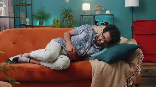 Man with Stomach Pain Lying on Couch