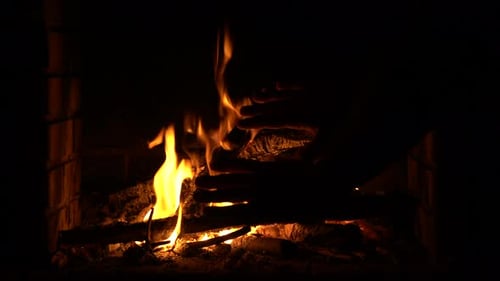 Warming hands in the fire in the fireplace