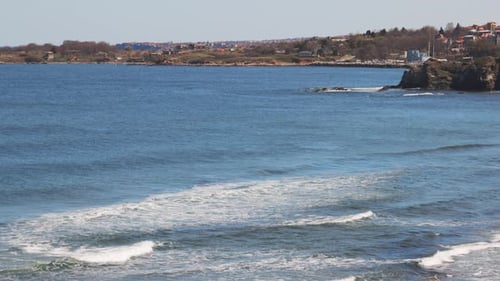 Costa com grama e hotéis à distância cercada pelo Mar Negro sob um céu claro