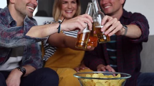 Friends Toasting and Drinking Beer Together at Home