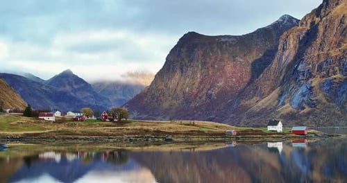 Real Time Zoom Out Aerial View of Small Village with Houses Located on Grassy Shore Near Calm