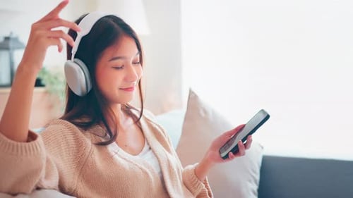 Woman Listening Music with Headphones Indoors Relaxing