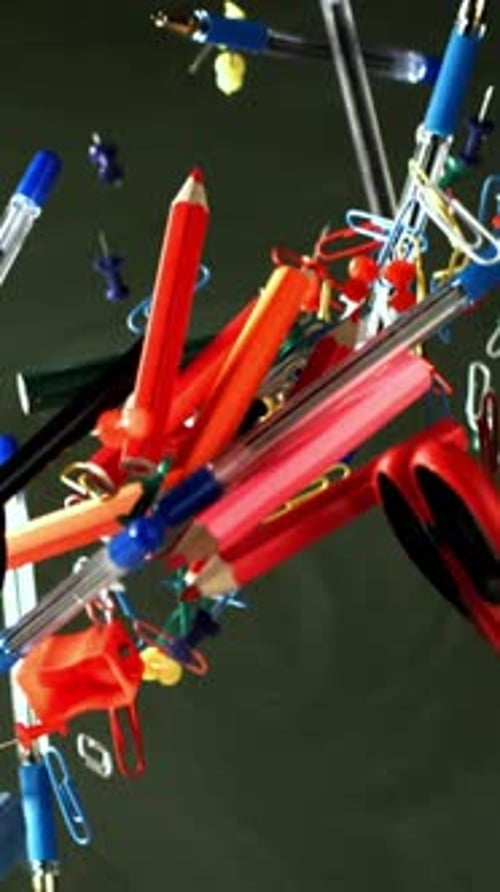 Different School Objects Fly and Fall Against the Background of the Blackboard Filmed on a Highspeed