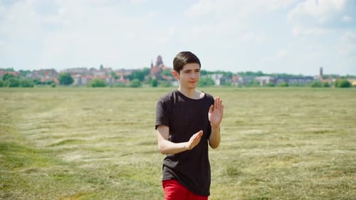 Young Adult Practices Martial Arts in Sunny Field