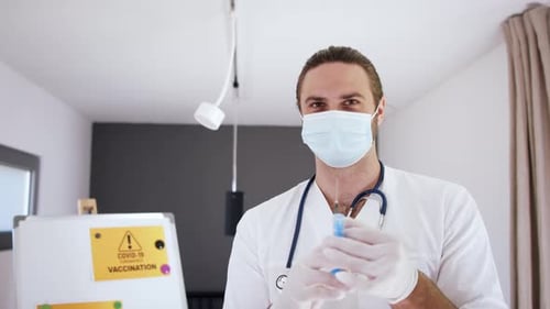Focused Doctor Holding Syringe Wearing Face Mask