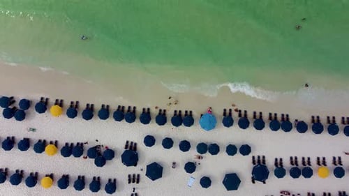 Beach Aerial with chair and colorful umbrella beach service. Miami Beach, Florida, USA. Aerial lands