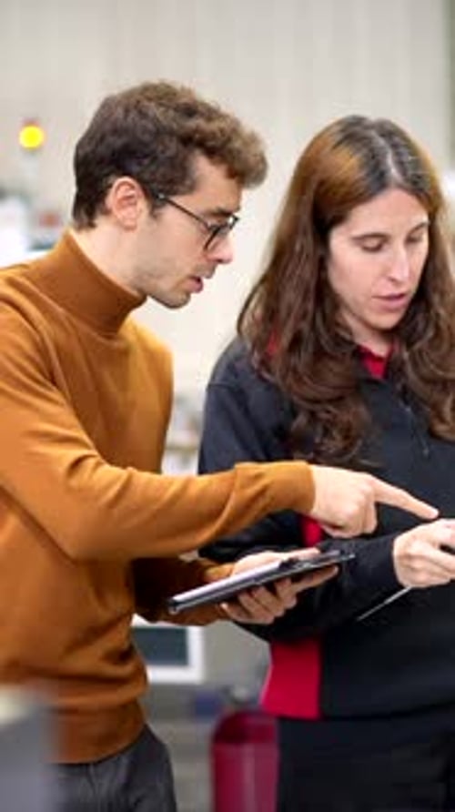 Engineers Talking While Using Digital Tablet in a Modern Factory