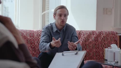 Man Consulting with Senior Therapist in Counseling Office