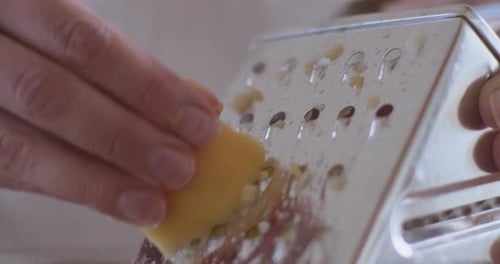 Woman Grating An Apple In Kitchen Baking Pie