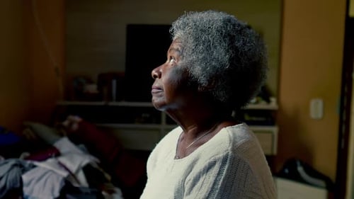 Thoughtful Senior Woman Sits in Quiet Home Interior