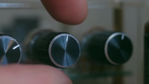 Finger Adjusts Knob on Electronic Equipment