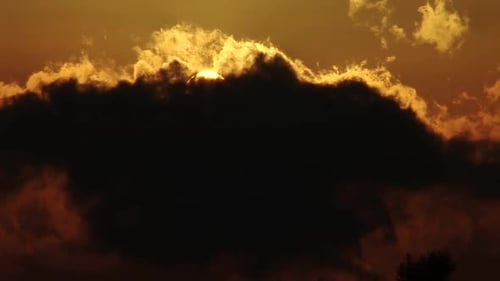 Time lapse of clouds moving while covering the sun during magic hour