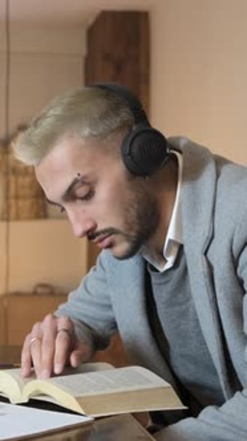 Man with Headphones Reading a Book Indoors