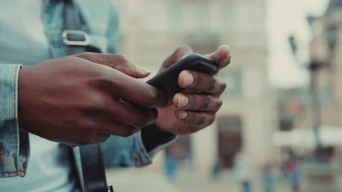 Close Up Hands Young African American Man Uses the Phone at the Street Business Shopping Internet