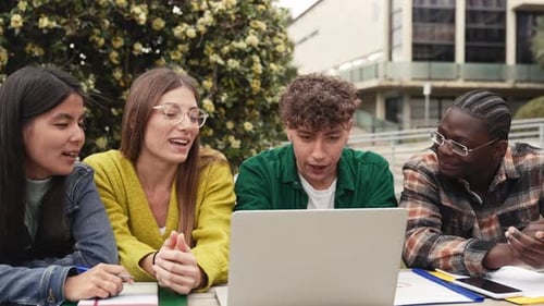 Diverse Students Studying Together Outdoors with Laptop