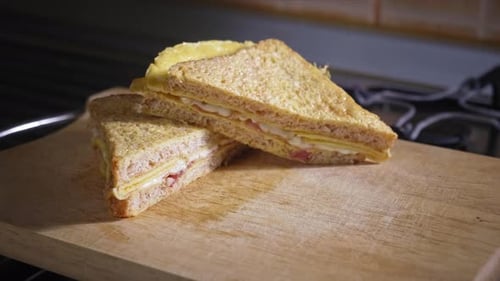 Breakfast Sandwiches Stacked on Wooden Cutting Board