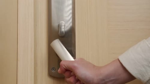 Hand Opening Hotel Door in Warmly Lit Interior