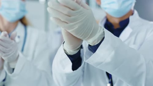 Medical Professionals Applauding Success Wearing PPE in Hospital