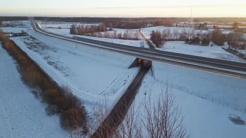 A Serene Winter Landscape Featuring a Blurry Highway Alongside Scenic SnowCovered Fields and Frosted