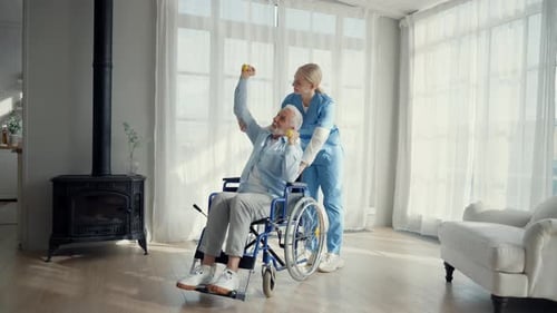 Woman Helps Senior Man Exercise in Wheelchair