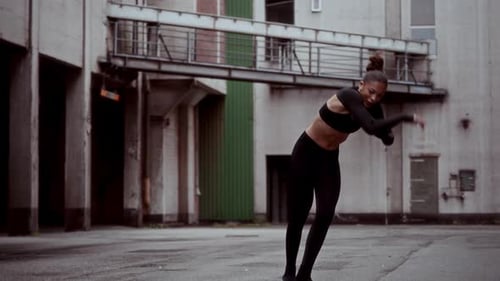 Woman Showcasing Modern Dance Skills In Urban Setting