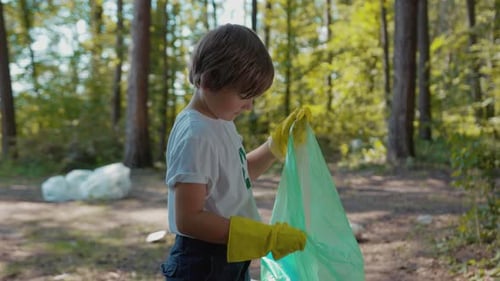 Child Holding Trash in Forest with Recycling Shirt