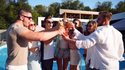 Friends Toasting Drinks at Pool Party on Sunny Day