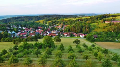 Small Village with Farms Trees Agricultural Fields and Orchards in Sunlight