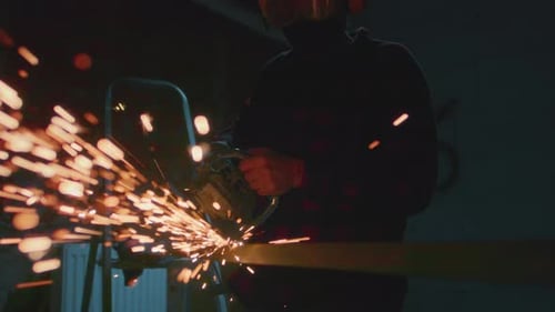 Man Working at Factory Cuts Metal with a Grinder Male at a Construction Site Cuts Off Piece Guy